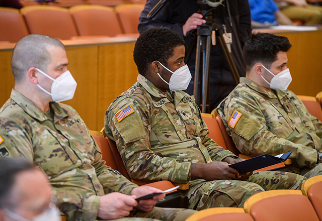 Members of the National Guard listen intently.