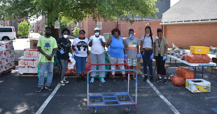 South Baltimore Partnership volunteers prepare to distribute fresh meat and produce to neighbors during the COVID-19 pandemic using a Baltimore Community ToolBank cart.