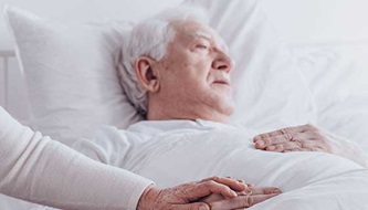 man in bed with a woman's hand holding his